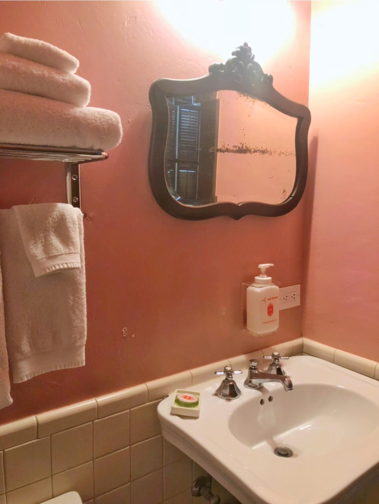 Pink painted walls, vintage tiles, and an antique mirror were sweet details in the slightly small-ish but lovely bathroom.