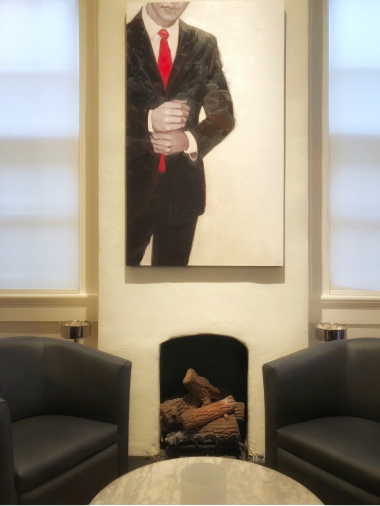 Painting of a man in a black suit with red tie at Effervescence champagne bar in New Orleans